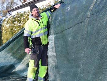 Man täcker växter med vinterduk för skydd mot kyla och frost.